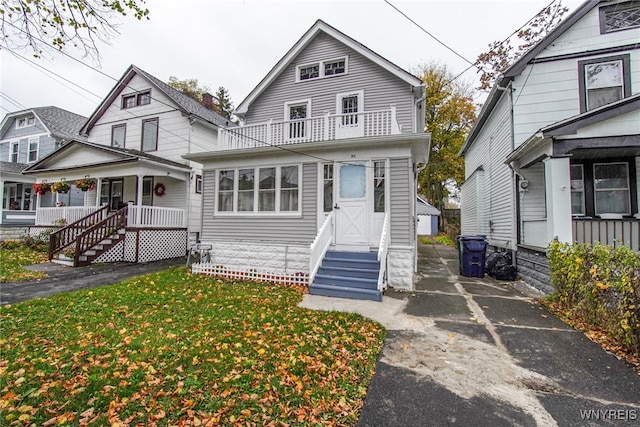 view of front of house featuring a balcony and a front yard