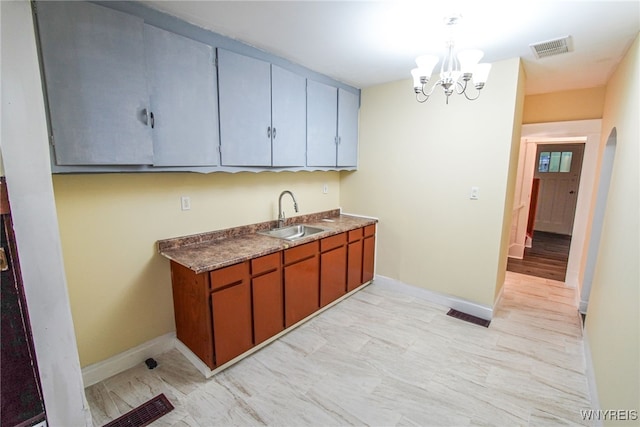 kitchen featuring sink, pendant lighting, and an inviting chandelier