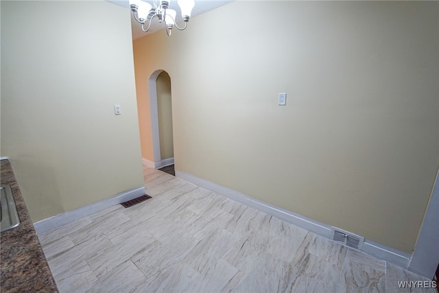 spare room with a notable chandelier