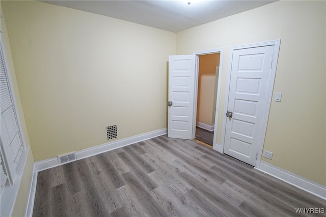 unfurnished bedroom with light wood-type flooring and a closet