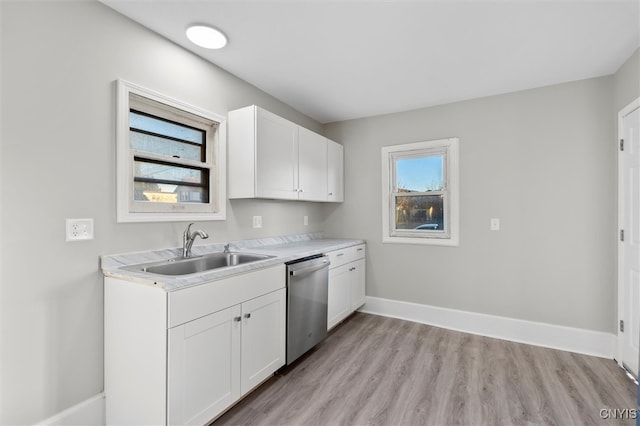 kitchen with white cabinetry, stainless steel dishwasher, plenty of natural light, and light hardwood / wood-style flooring