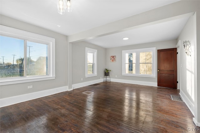 empty room with plenty of natural light and dark hardwood / wood-style floors