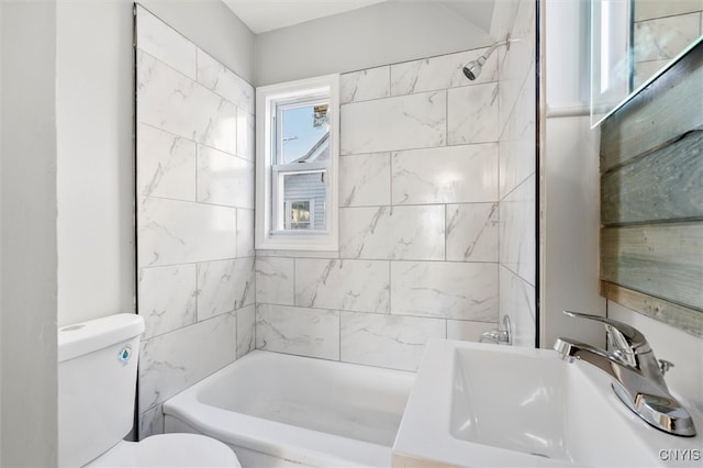 full bathroom featuring sink, tiled shower / bath combo, and toilet