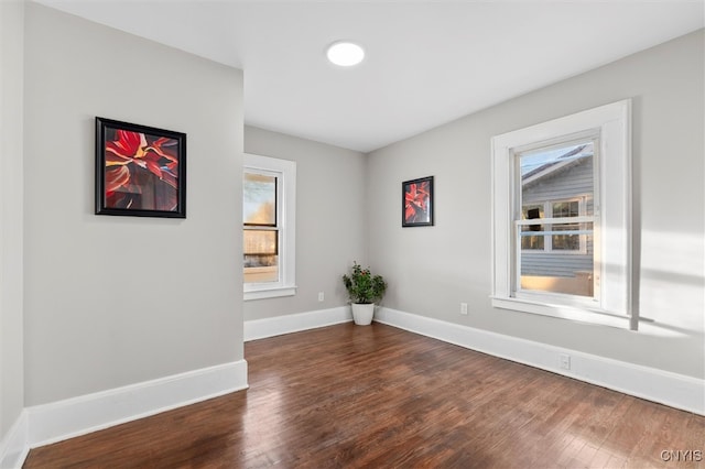 spare room with dark hardwood / wood-style floors and a healthy amount of sunlight