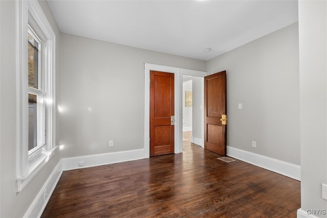 unfurnished room with dark hardwood / wood-style floors