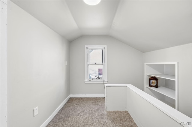 additional living space featuring lofted ceiling and light carpet