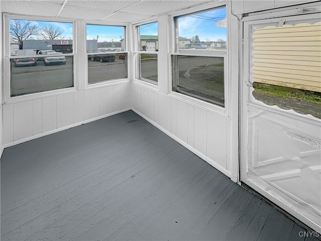 unfurnished sunroom featuring a wealth of natural light and a drop ceiling