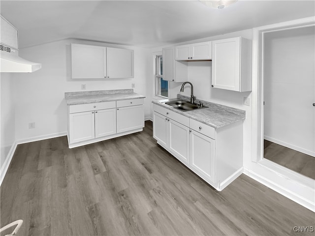 kitchen with white cabinetry, sink, and light hardwood / wood-style flooring