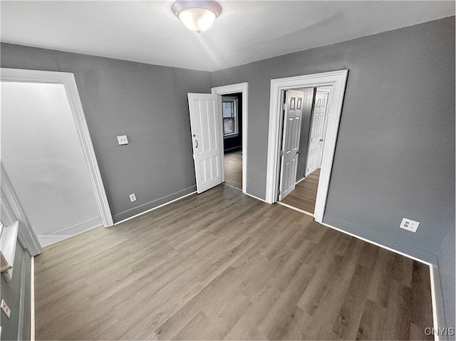 unfurnished bedroom with light wood-type flooring and a closet