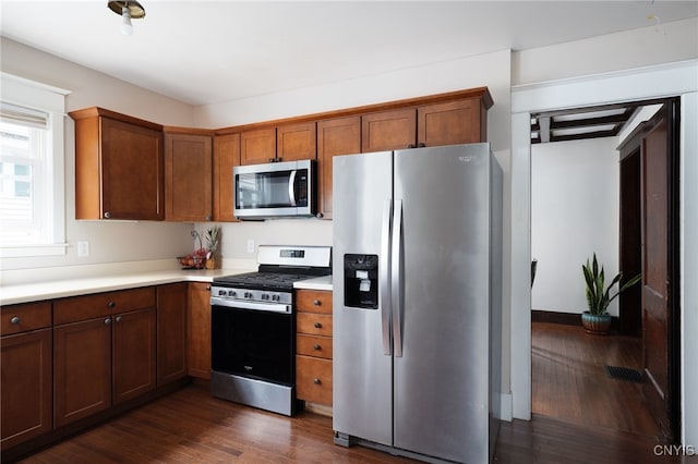 kitchen with dark wood-type flooring and appliances with stainless steel finishes