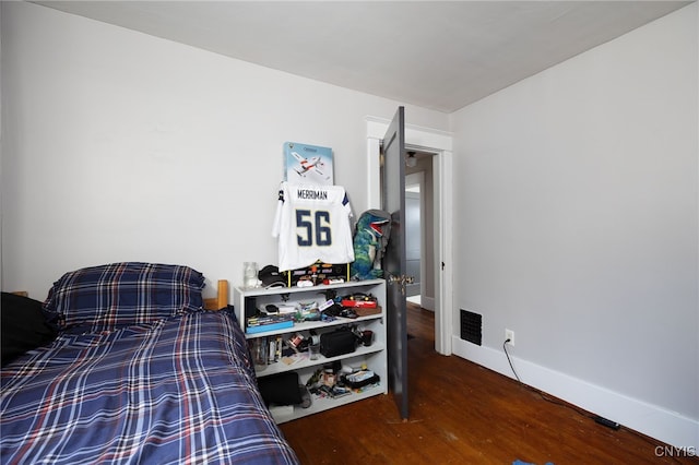 bedroom with dark hardwood / wood-style flooring