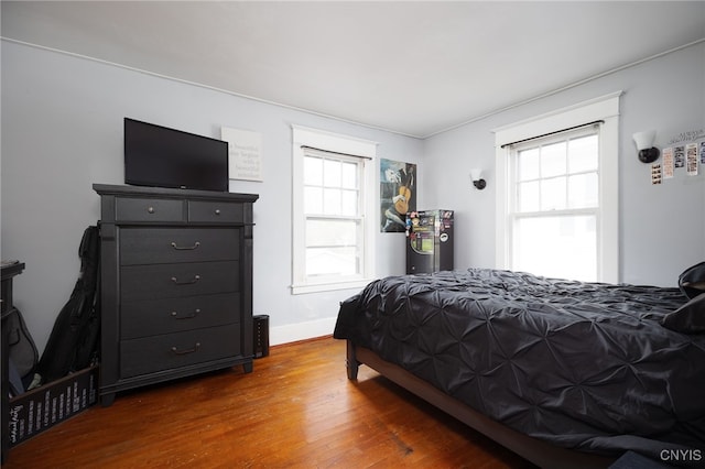 bedroom with dark hardwood / wood-style flooring and multiple windows