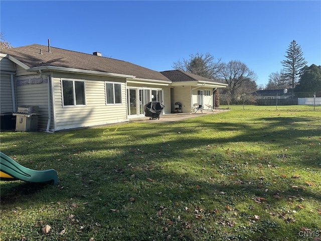 rear view of house featuring a patio and a lawn