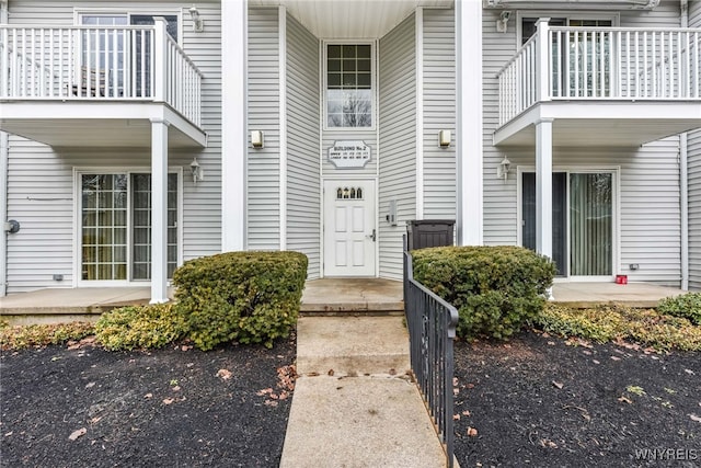 view of exterior entry with a balcony