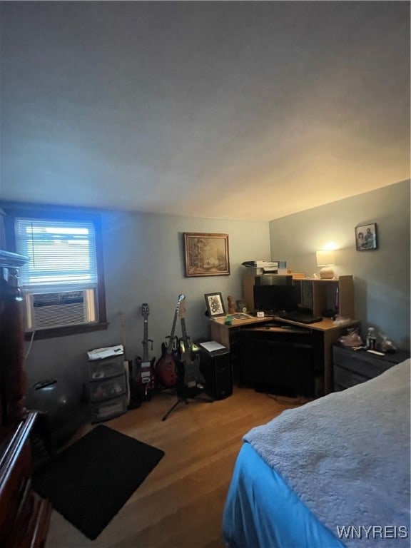 bedroom with cooling unit and wood-type flooring