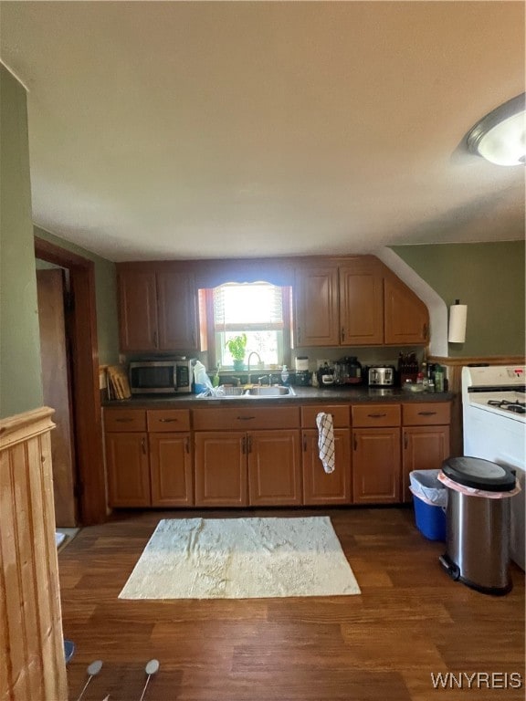 kitchen featuring dark hardwood / wood-style flooring, white range with gas stovetop, and sink