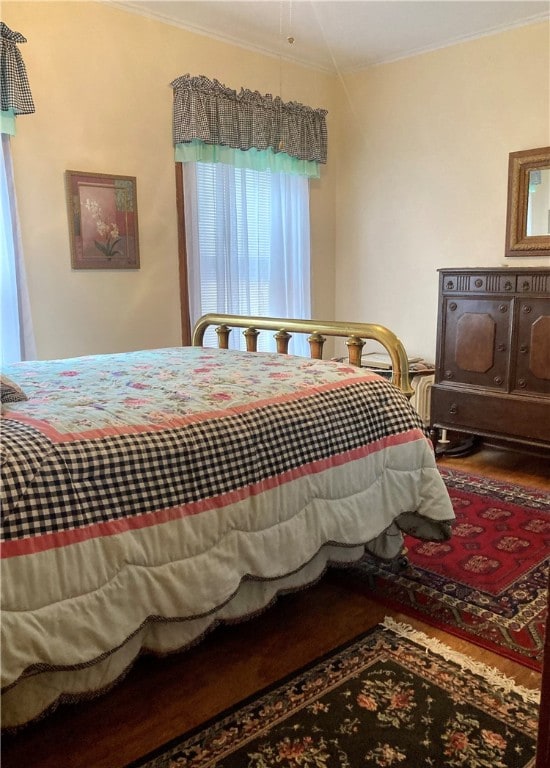 bedroom featuring hardwood / wood-style flooring and crown molding