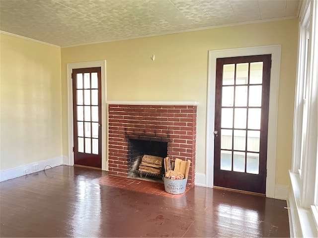 unfurnished living room featuring ornamental molding, dark hardwood / wood-style flooring, a brick fireplace, and a wealth of natural light