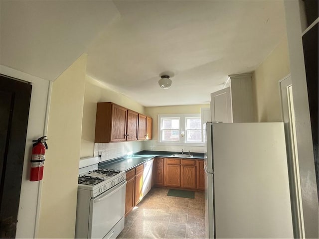 kitchen with sink, dishwasher, gas range gas stove, and stainless steel refrigerator