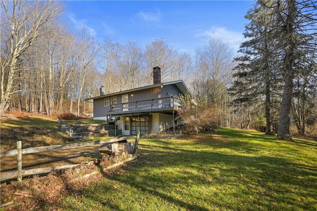 back of property with a lawn and a wooden deck