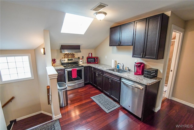 67 Harvard Pl, Buffalo, NY 14209 - kitchen featuring dark hardwood / wood-style flooring, vaulted ceiling with skylight, wall chimney exhaust hood, and stainless steel appliances