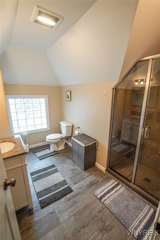 67 Harvard Pl, Buffalo, NY 14209 - bathroom with wood-type flooring, an enclosed shower, lofted ceiling, toilet, and vanity
