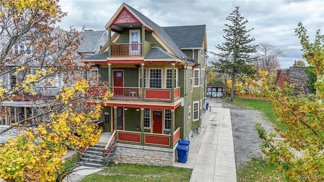 victorian home with a balcony and an outbuilding