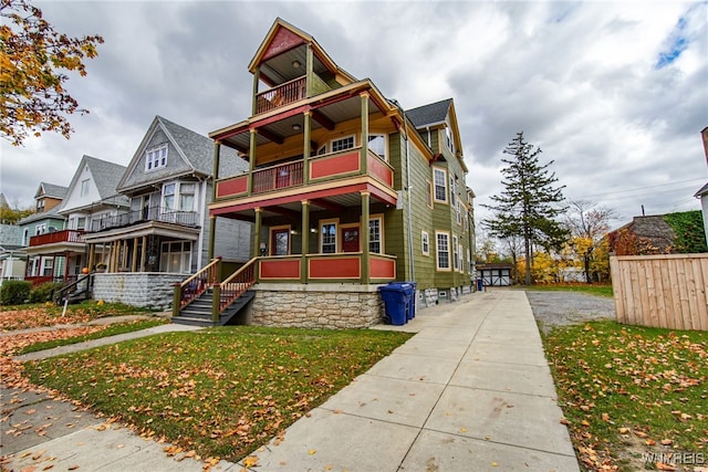 view of front of property with a balcony and a front yard