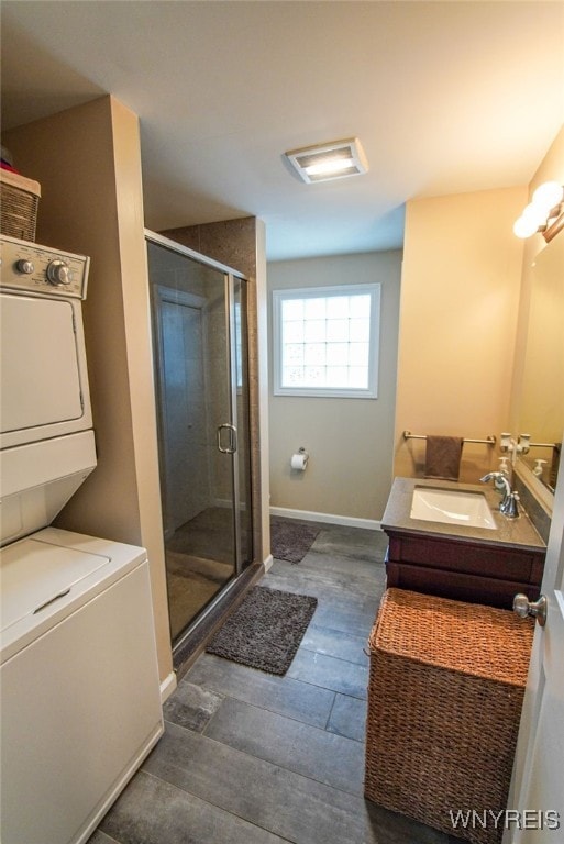 67 Harvard Pl, Buffalo, NY 14209 - bathroom featuring vanity, wood-type flooring, stacked washer / dryer, and walk in shower
