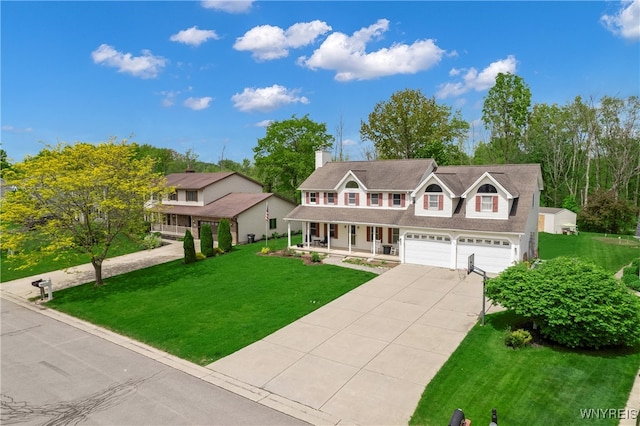 view of front of house with covered porch, a garage, and a front lawn