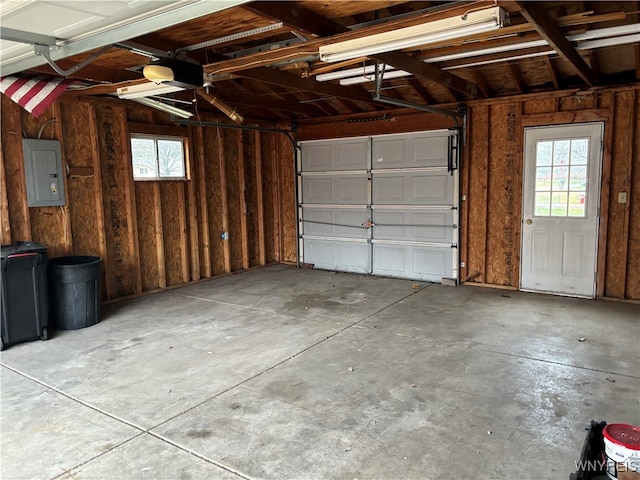 garage with a garage door opener and electric panel