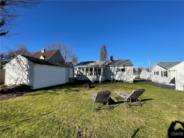 rear view of house with a sunroom and a lawn