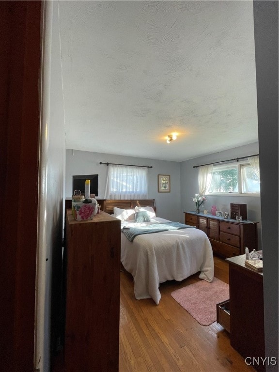 bedroom with wood-type flooring and a textured ceiling