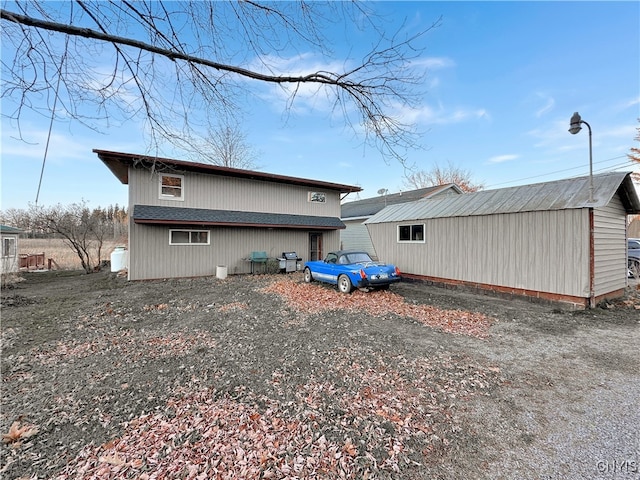 back of property featuring an outbuilding