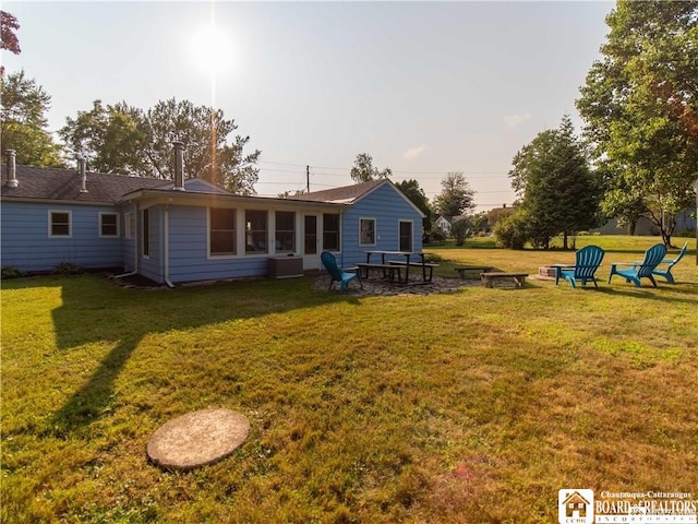 back of house featuring a yard and central AC unit