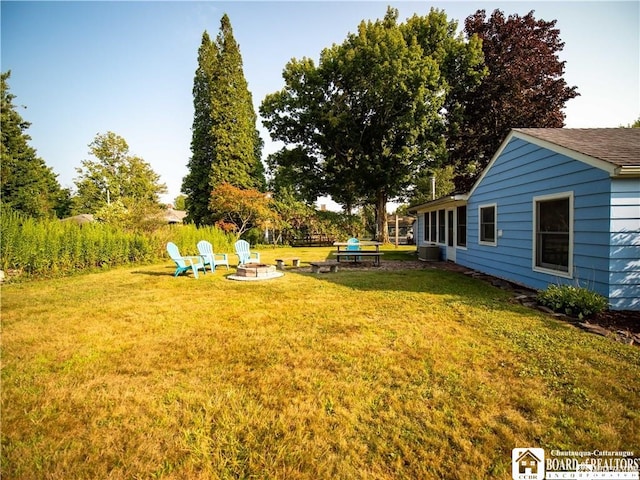 view of yard featuring central AC and a fire pit