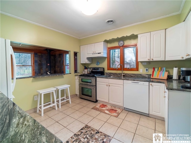 kitchen with a wealth of natural light, sink, white cabinets, and white appliances