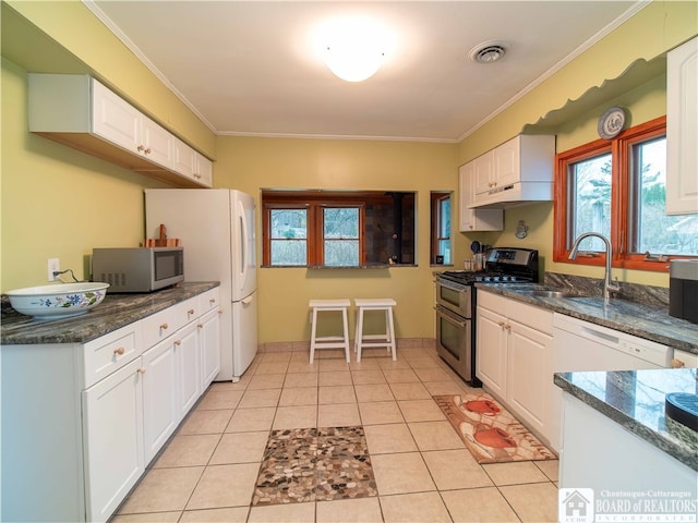 kitchen featuring sink, white cabinets, light tile patterned floors, and appliances with stainless steel finishes