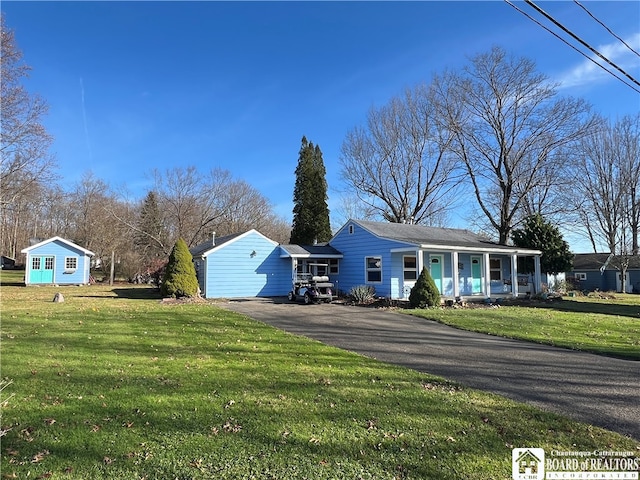 single story home with a shed, a front lawn, and a porch