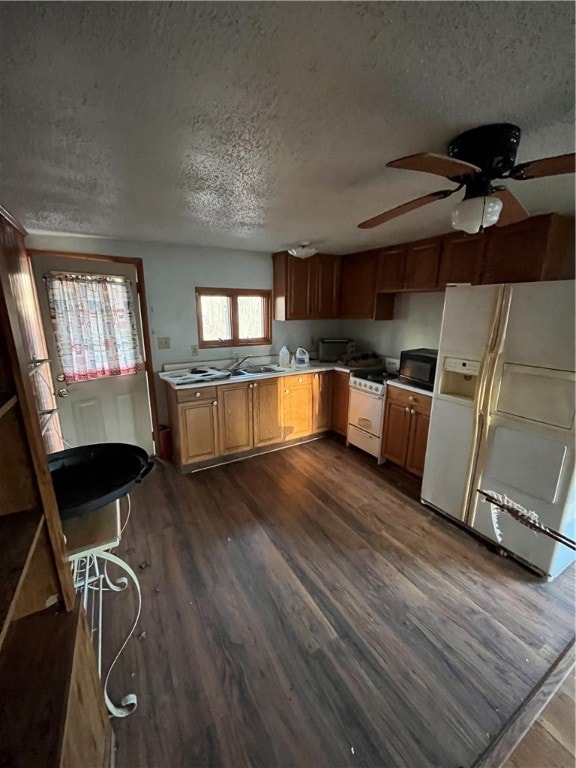 kitchen featuring a textured ceiling, white appliances, ceiling fan, and dark wood-type flooring