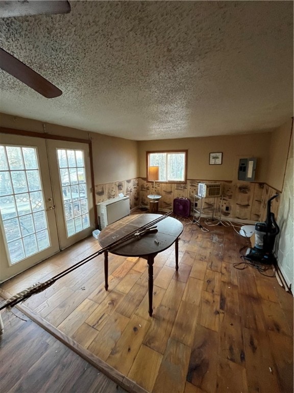 interior space featuring a textured ceiling, a wall unit AC, and light hardwood / wood-style flooring