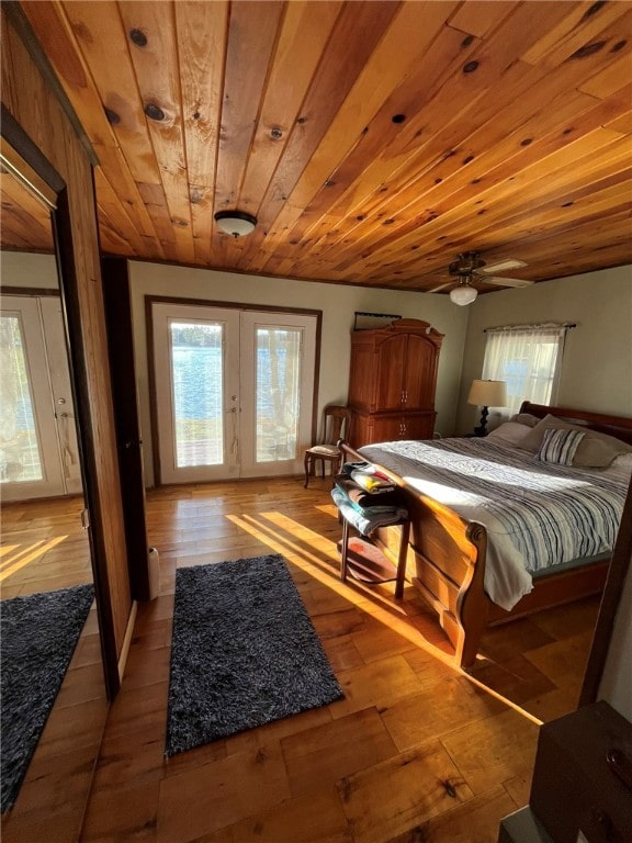 bedroom with light hardwood / wood-style flooring, wood ceiling, and french doors