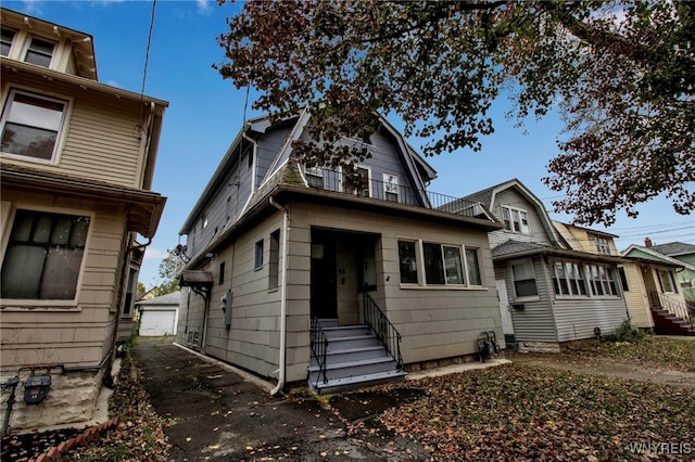 view of front of property featuring a balcony, a garage, and an outdoor structure