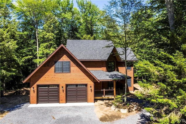2773 S Shore Rd, Webb, NY 13420 - chalet / cabin featuring covered porch, a shingled roof, driveway, and a garage
