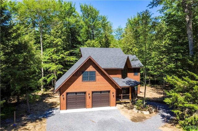 log cabin with a garage and covered porch