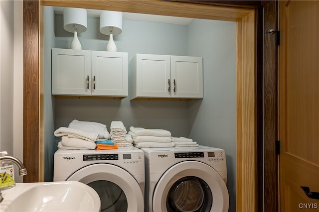 laundry area featuring cabinets, separate washer and dryer, and sink