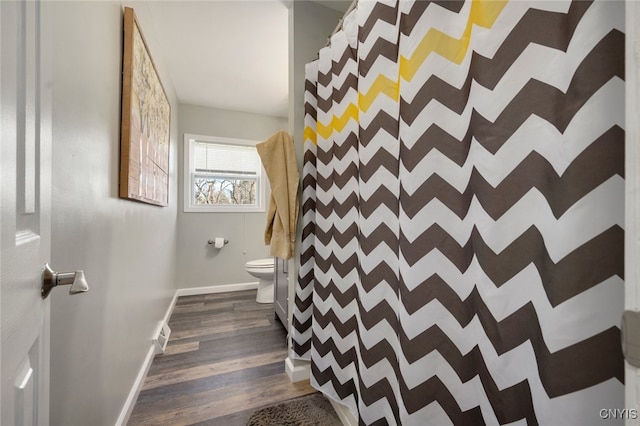 bathroom featuring hardwood / wood-style floors, a shower with curtain, and toilet