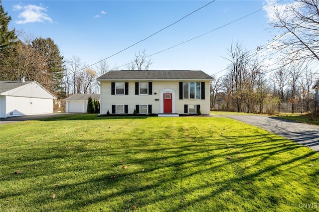 raised ranch featuring a garage, an outdoor structure, and a front yard