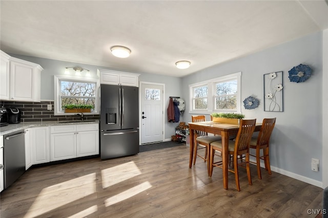 kitchen with white cabinetry, a wealth of natural light, dark wood-type flooring, and appliances with stainless steel finishes