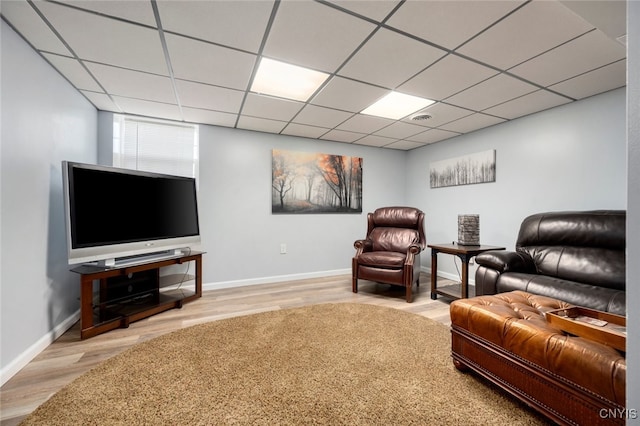 living room with hardwood / wood-style floors and a paneled ceiling